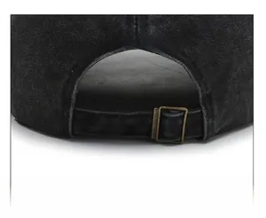 Detail of adjustable bronze metal buckle and washed denim texture on baseball cap