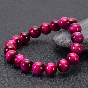 Macro detail of magenta tiger eye stone beads with natural cat-eye light effect