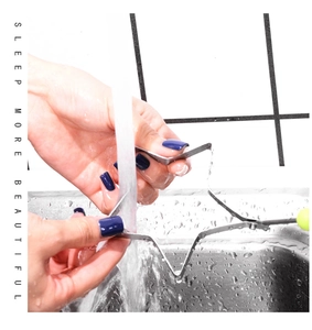 Close-up of hand washing star-shaped stainless steel egg mold under kitchen faucet water