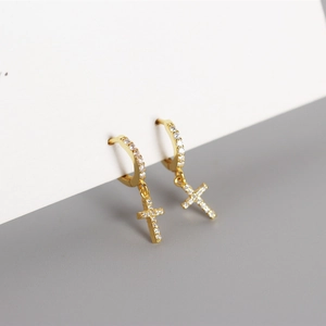 Detail of gold cross drop earrings with sparkling pavé cubic zirconia inlay