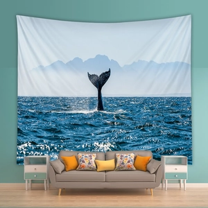 Nordic wall tapestry with whale tail ocean scenery over modern grey sofa in a bedroom