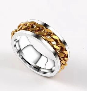 Detail of silver stainless steel ring with an integrated golden Cuban chain spinner link