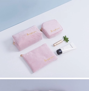 Detailed top view of 3-piece set of pink velvet makeup bags with golden embroidery