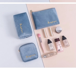 Set of three blue velvet cosmetic bags in various sizes with elegant gold embroidery