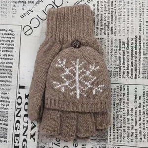 Texture de maille détaillée des mitaines en laine marron avec motifs de flocons blancs