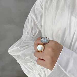 Minimalist 925 sterling silver shell rings in gold and silver finish on a female model