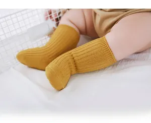 Close-up of ginger yellow ribbed knit baby mid-tube socks with soft elastic texture
