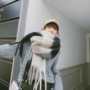 Detailed view of beige black and grey checkered knit scarf with soft fringe edges