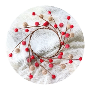 Christmas wreath with red berries and gold glitter balls on white faux fur background