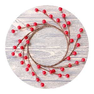 Round Christmas wreath with red shiny artificial berries on rustic wood background