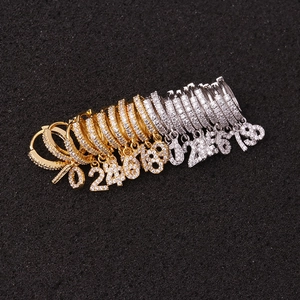 Reihe von gold- und silbernen Zahlenohrringen mit Zirkonia auf schwarzem Schaumstoff