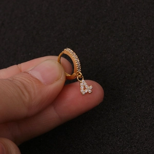 Detail-Makroansicht eines Goldohrrings mit Zirkon-Reif und einem Anhänger in Form der 4