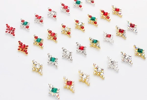 Vue macro de bijoux d'ongles en losange avec pierres rouges émeraudes et perles