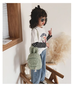 Détail du sac à dos vert en laine d'agneau pour enfant avec oreilles de lapin et ourson
