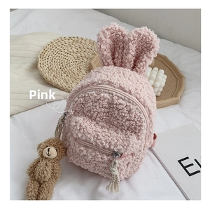 Détail du sac à dos enfant en polaire rose avec oreilles de lapin et pendentif ours