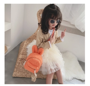 Détail du sac à dos enfant en polaire orange avec oreilles de lapin et pendentif ours