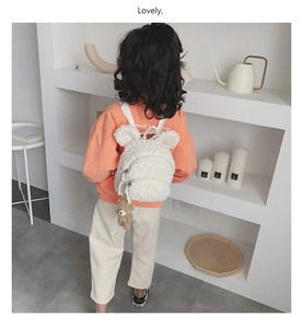 Détail du sac à dos enfant en peluche blanche avec oreilles d'ours et petit porte-clé