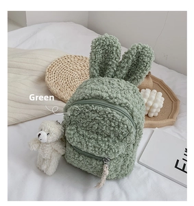 Détail d'un sac à dos enfant en polaire verte avec oreilles de lapin et petit ours