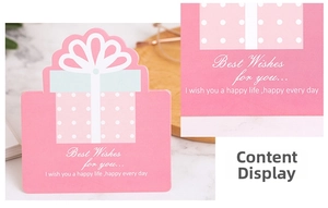 Détail d'une carte de vœux rose en forme de cadeau avec des pois et un ruban