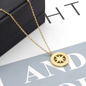 Gold-plated stainless steel necklace with round North Star medal pendant on jewelry box