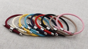 Array of colorful braided rope bracelets with adjustable metal slides and buckles