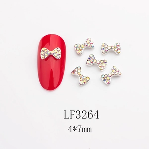 Vue macro détaillée de bijoux d'ongles nœuds 4x7mm avec strass AB sur ongles rouges
