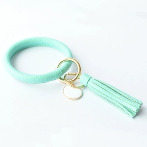 Detailed close-up of mint green PU leather keychain bangle with tassel and gold hardware
