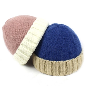Flat lay detail of two-tone knit beanies in pink and navy with ribbed texture