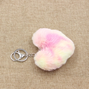 Macro detail of a colorful tie-dye plush heart keychain on a rustic burlap background