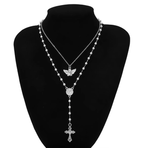 Detail showing silver angel pendant with beaded rosary chain and cross on a mannequin