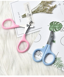 Close-up of pink and blue pet nail clippers for cats on a soft decorative background