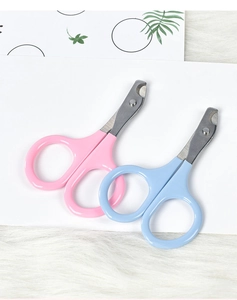 Flat lay of pink and blue pet nail clippers with stainless steel blades on plush background
