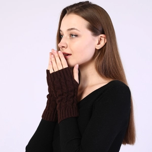 Detailed close-up of dark coffee cable knit fingerless gloves on a model's arm