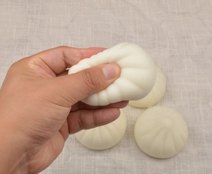 Macro detail of squishy bun toy showing slow rebound texture and realistic food shape
