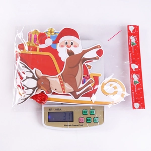 Packaged Christmas paper banners with Santa and reindeer on a scale weighing 31g