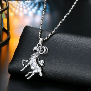 Detailed view of silver ram pendant on a sturdy box chain against dark leather padding