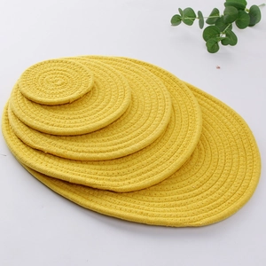 Macro detail of five yellow hand-woven cotton rope placemats for heat resistance