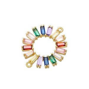 Macro shot of circular gold connector with radial multi-colored zircon stones and dual loops