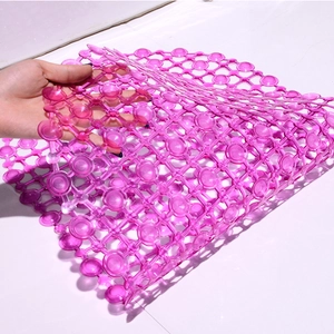 Pink translucent PVC bathroom anti-slip mat with suction cups shown for flexibility