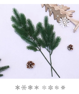Close-up of artificial pine needles and pine cones for Christmas DIY decor on white fabric