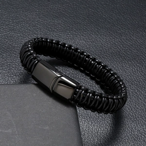 Detailed view of black multilayer braided leather bracelet with dark magnetic clasp