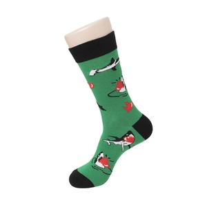 Detail view of green mid-calf socks with cartoon shark patterns and black trim
