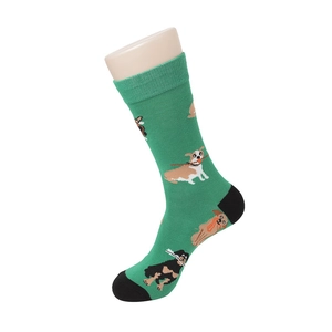 Detail of green knit crew socks featuring cartoon dog patterns and black contrast toe