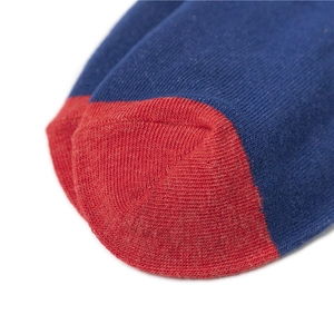 Close-up detail of knitted cotton crew socks showing red toe stitching and blue fabric
