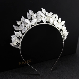 Macro detail of a silver metallic leaf headband with intricate leaf textures on black background