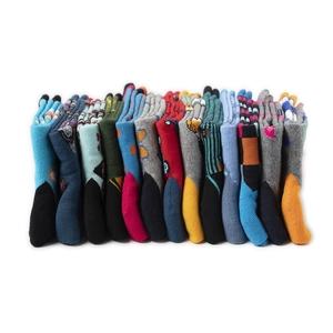 Détail de chaussettes en maille colorées avec divers motifs créatifs sur fond blanc pur
