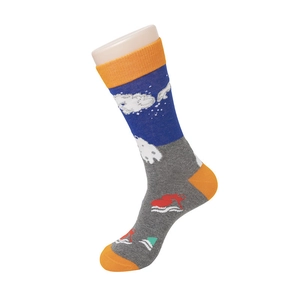 Détail de chaussettes en tricot créatives avec motifs de surfeurs et vagues bleues