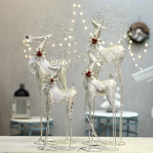 Silver iron wire reindeer decorations with festive red berry scarves for Christmas decor