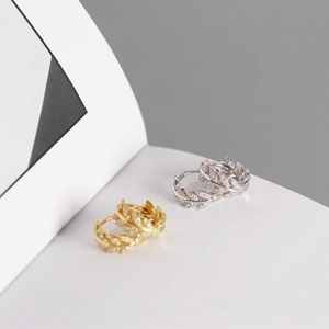 Close-up of S925 silver olive leaf hoop earrings with diamonds in gold and silver