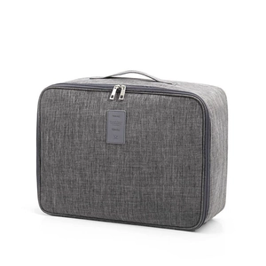 Grand sac de voyage gris avec double fermeture éclair et passant pour valise à roulettes